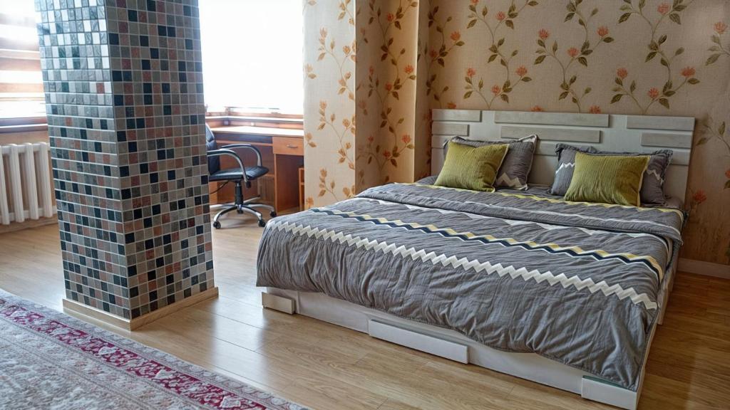 1 dormitorio con 1 cama y un pilar de ladrillo en Home hearth - Домашний очаг en Dusambé