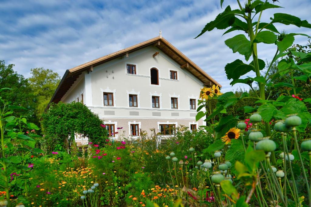 un gran edificio blanco con un campo de flores en Gästehof Huber, en Forstern