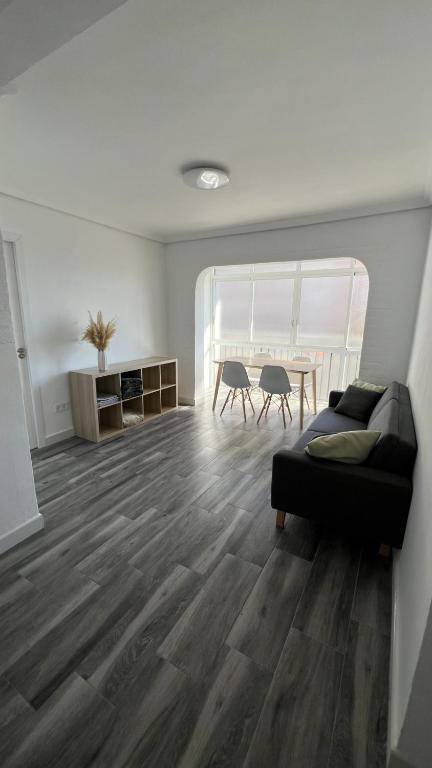 ein Wohnzimmer mit einem Sofa und einem Tisch in der Unterkunft Piso Universidad Alicante in San Vicente del Raspeig