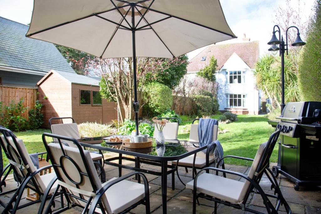 a patio with a table and chairs with an umbrella at Toller House in Exmouth