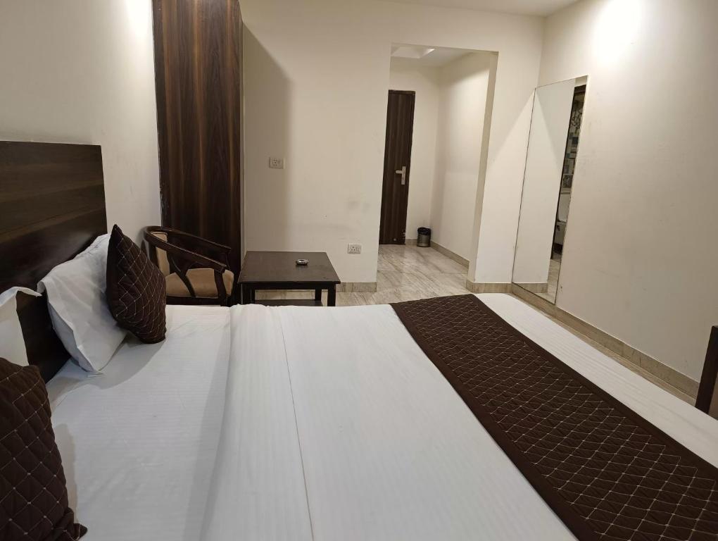 a bedroom with a large bed and a table at Hotel Samara Kingdom Near Delhi Airport in New Delhi