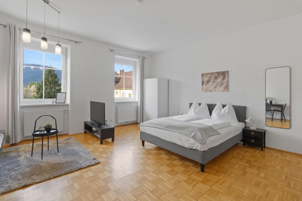 a bedroom with a bed and two windows at StayEasy Apartments Krieglach W1 