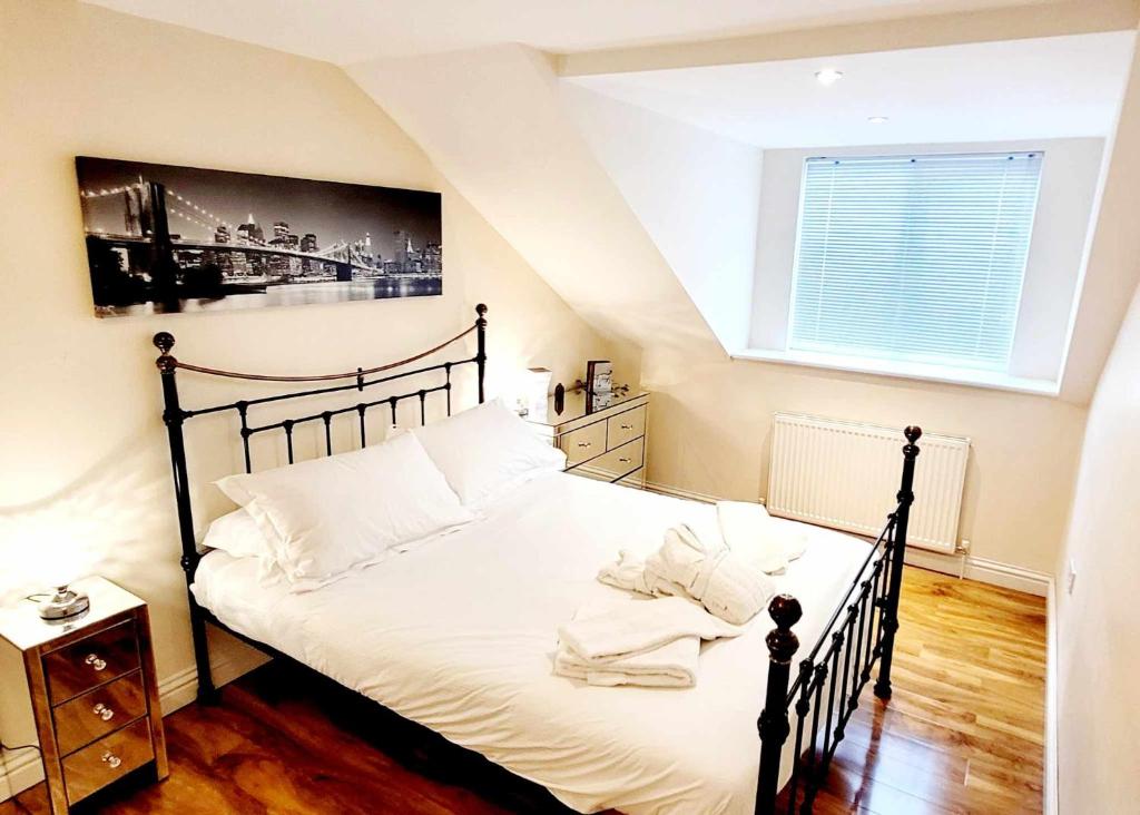 a bedroom with a large bed with white sheets at Apartment 4 - striking, 2 bedroom luxury apartment - close to town, mainline rail & theatre in Darlington