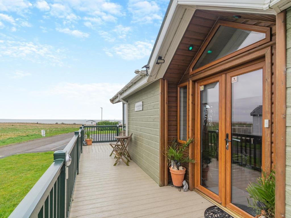 a house with a deck with a view of the ocean at Sea View Lodge in Horden