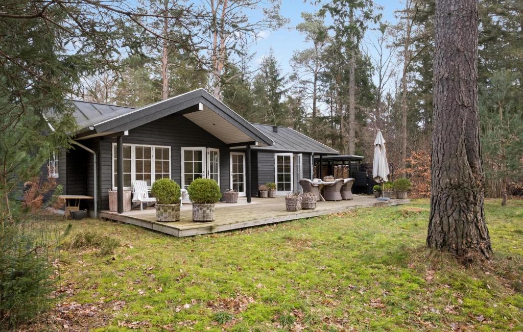 uma pequena cabana com um deque na floresta em 3 Bedroom Amazing Home In Frederiksvrk em Frederiksværk