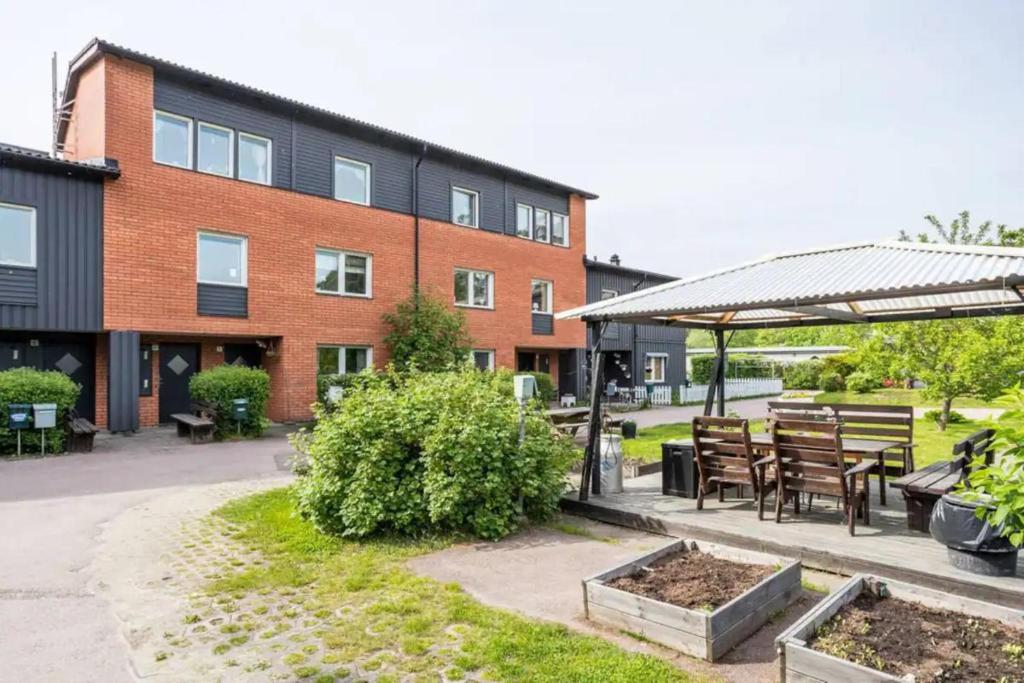 un bâtiment avec une table, des chaises et une terrasse dans l'établissement Karlstad Unic House kronoparken, à Karlstad