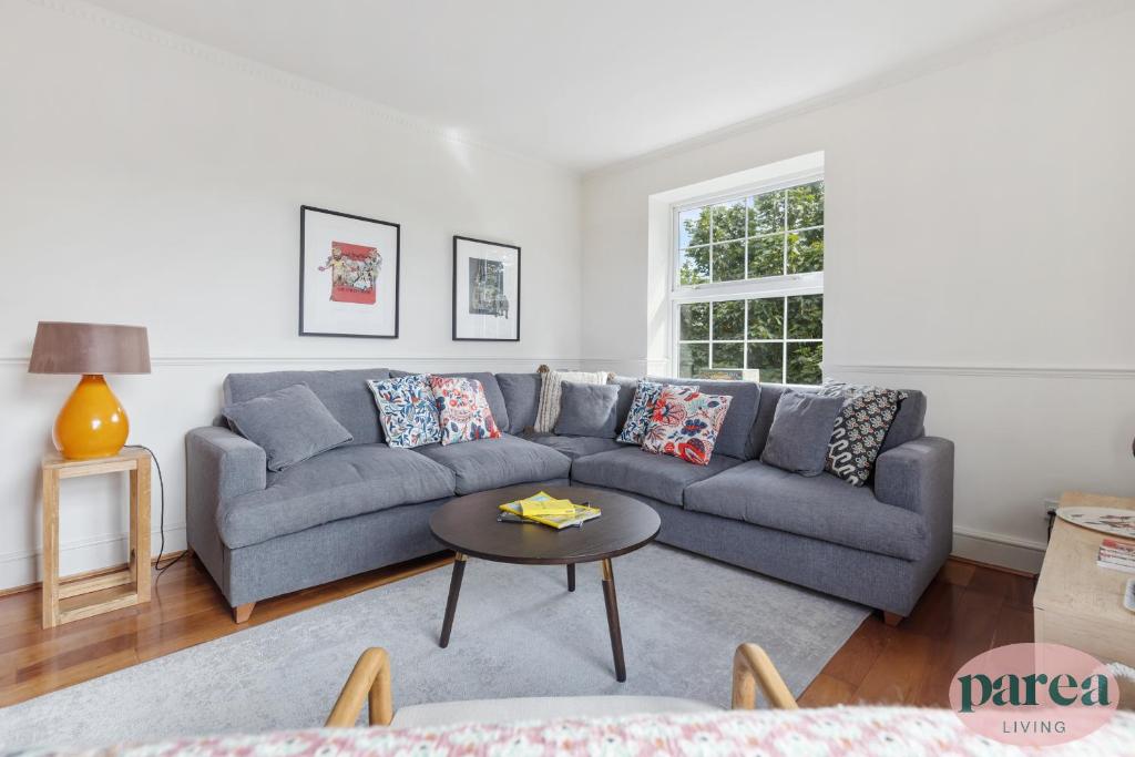 a living room with a blue couch and a table at Parea Living - Stylish Islington 1-Bed Flat, 6min Walk to Tube in London