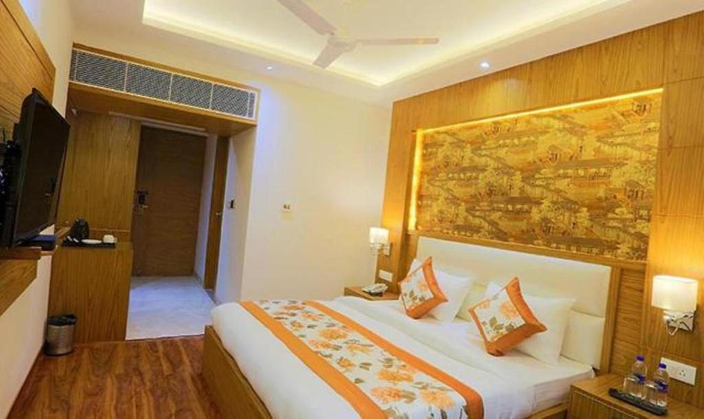 1 dormitorio con 1 cama y una gran pintura en la pared en FabHotel Prime Star 17 en Nueva Delhi