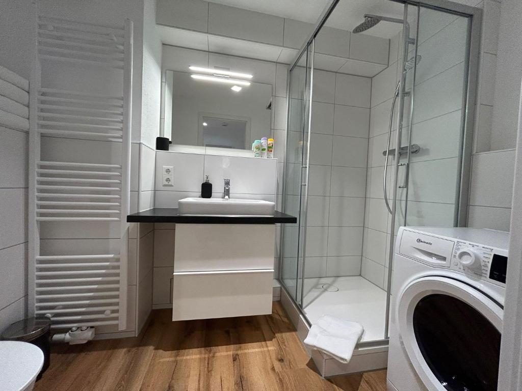 a bathroom with a shower sink and a washing machine at City Apartment mit TG Stellplatz - Glücks-Quartier Urban 01 in Pforzheim