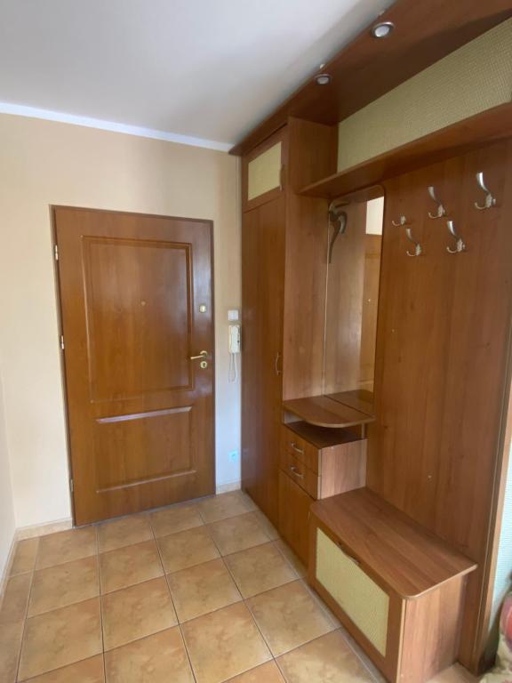 a kitchen with wooden cabinets and a door at Apartament „Na wydmie” in Ustka