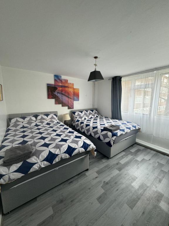 a bedroom with two beds and a window at Hatton Homes - Tottenham Hotspurs Stadium in London