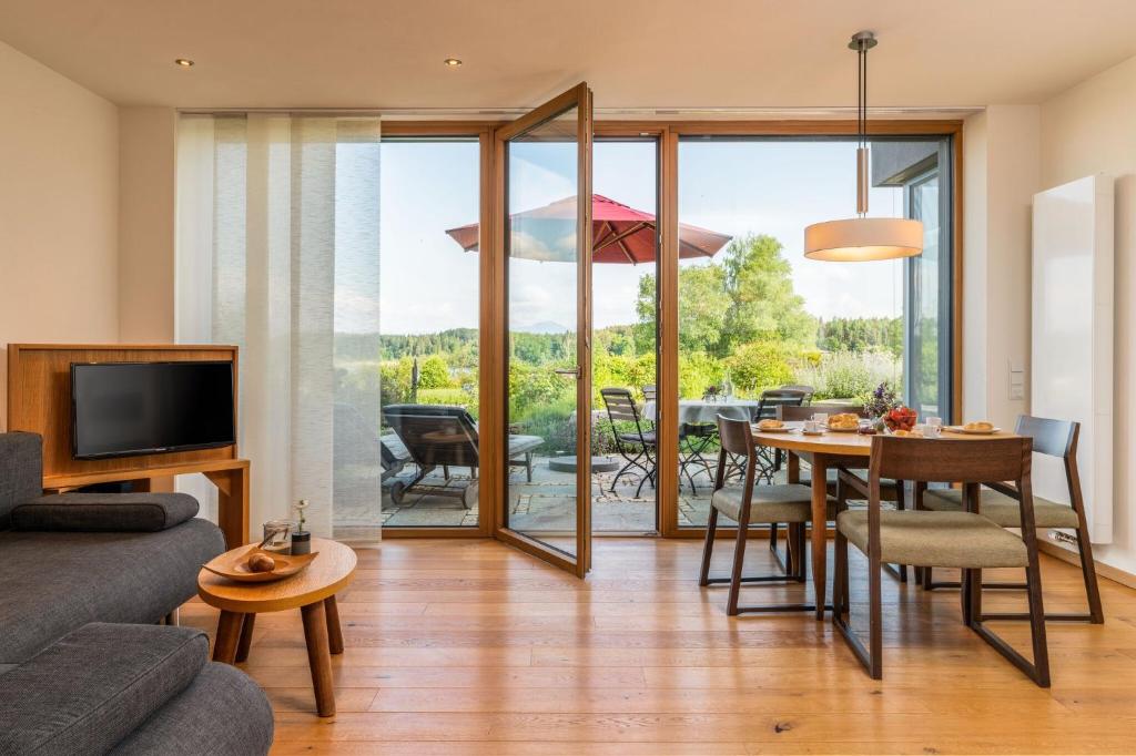 ein Wohnzimmer mit einem Tisch und einem Esszimmer in der Unterkunft Ferienwohnung Rosengarten in Bad Endorf
