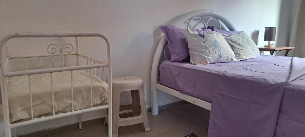 a bedroom with a white bed and a crib at Homestay Maio Apartment in Vila do Maio