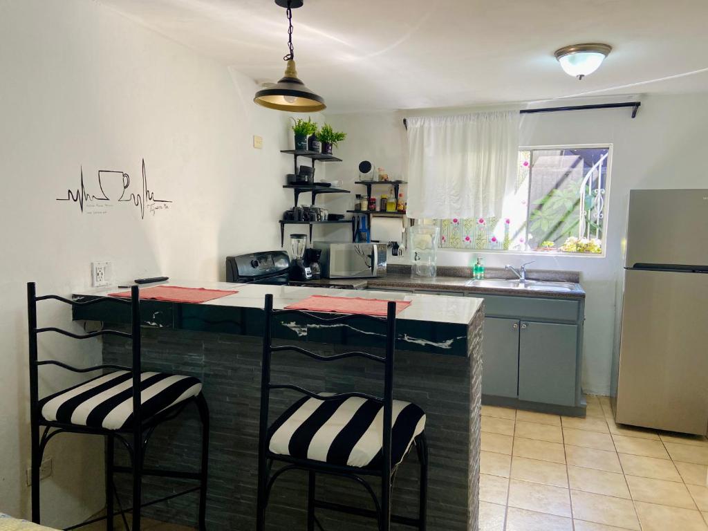 a kitchen with a counter and two bar stools at Zebra Studio in Tijuana