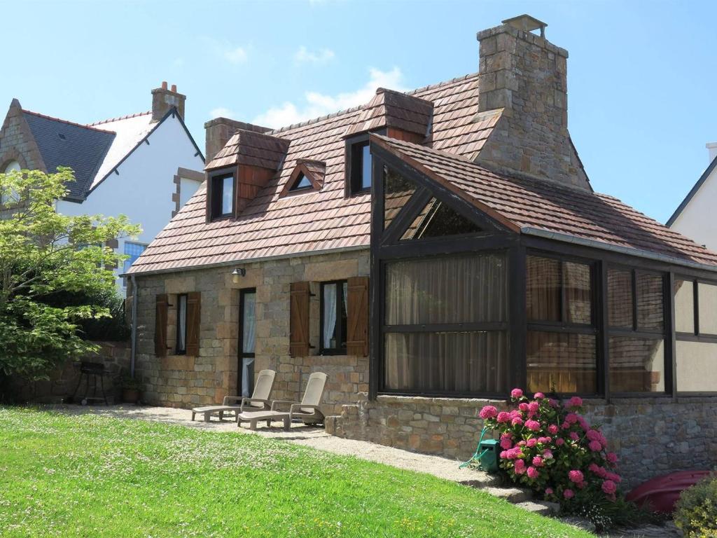 ein Steinhaus mit zwei Stühlen davor in der Unterkunft Maison bretonne avec jardin à 50m de la baie Ste Anne - FR-1-368-252 in Trégastel