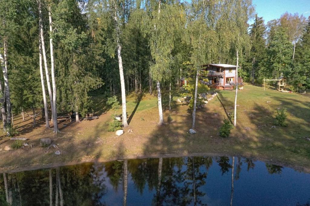an aerial view of a cabin in the woods next to a lake at Elupuu forest cabin with sauna in Nooska