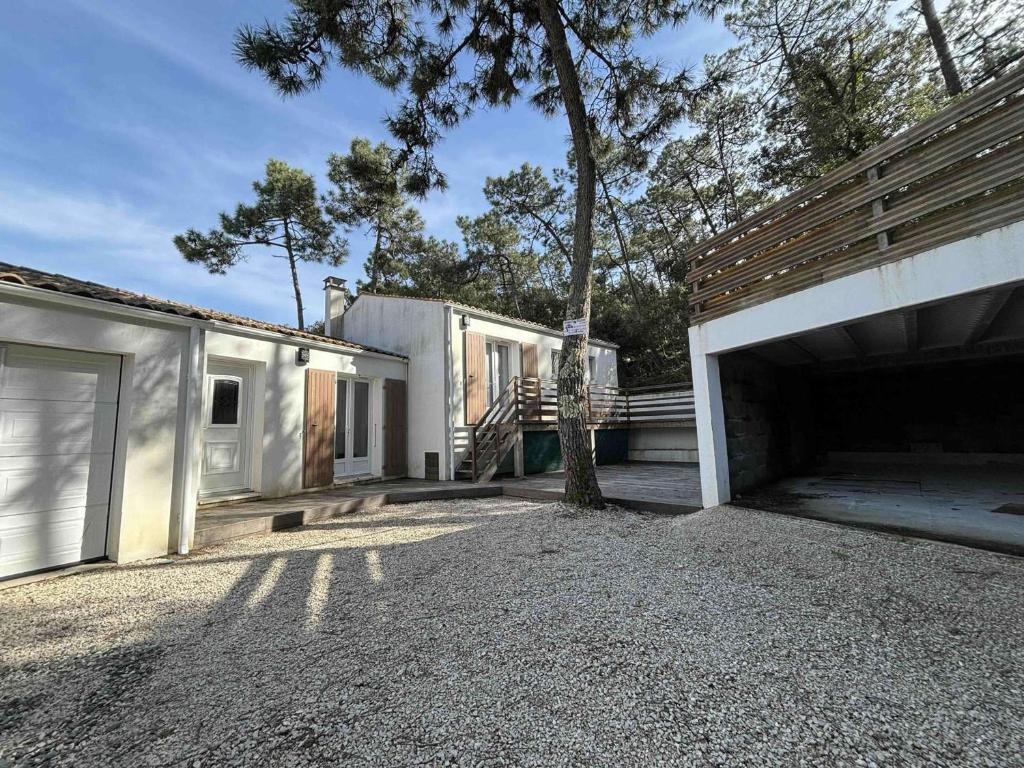 une maison avec un garage et un arbre dans l'allée dans l'établissement Maison Saint-Georges-d'Oléron, 4 pièces, 6 personnes - FR-1-246A-133, à Saint-Georges-dʼOléron