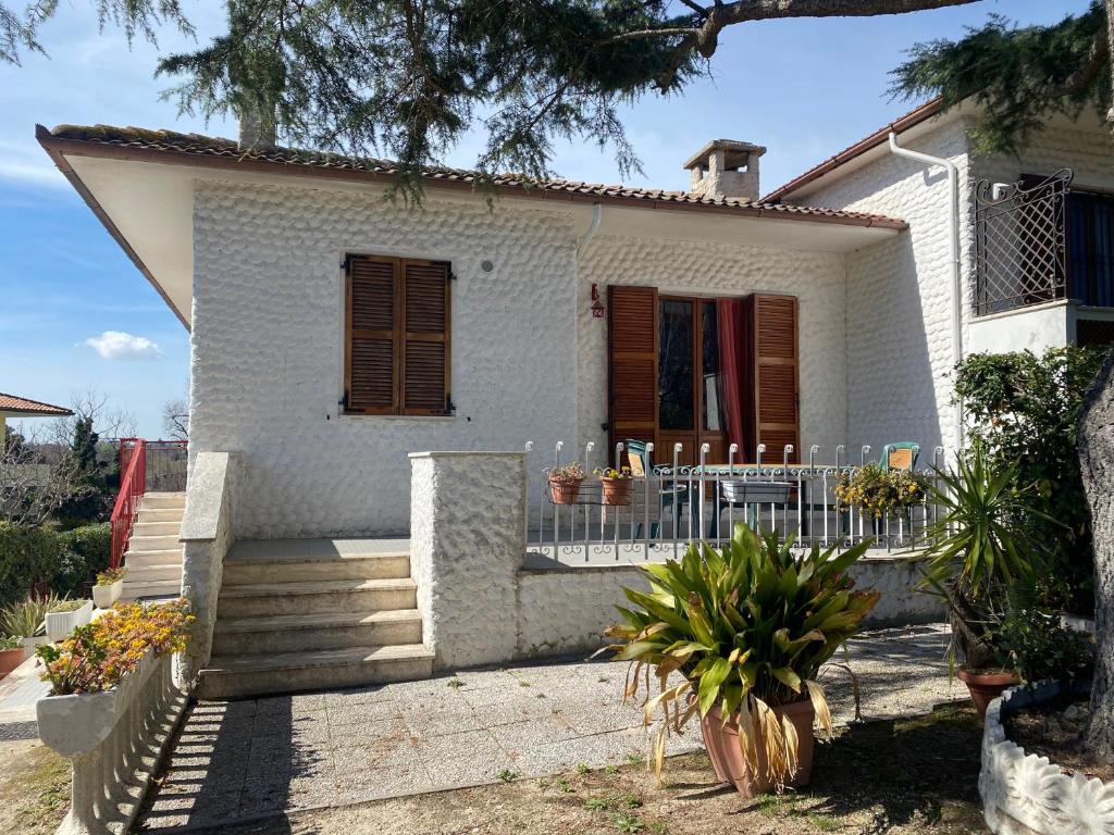 een klein wit huis met een veranda en een trap bij Bilocale 4 posti terrazza posto auto in Numana