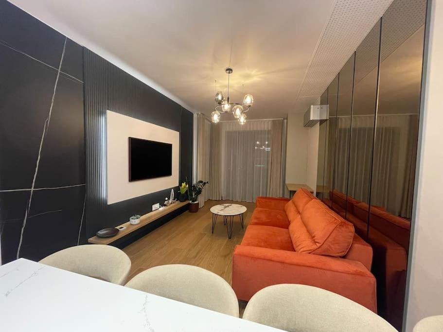 - un salon avec un canapé orange et une télévision dans l'établissement Boma Central Sunset View, à Bucarest