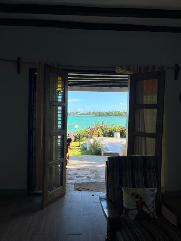una puerta abierta a una habitación con vistas al océano en Malcom residence 2, en Mdudu Mkubwa