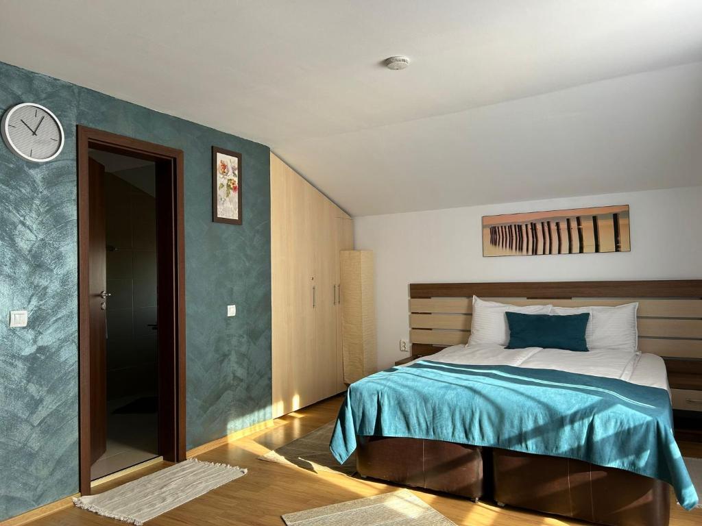 1 dormitorio con 1 cama y reloj en la pared en Party House, en Tunarii