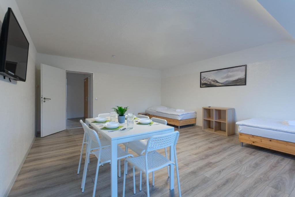 a room with a table and chairs and a bed at T&K Apartments - 3 Room Apartment with Balcony in Essen