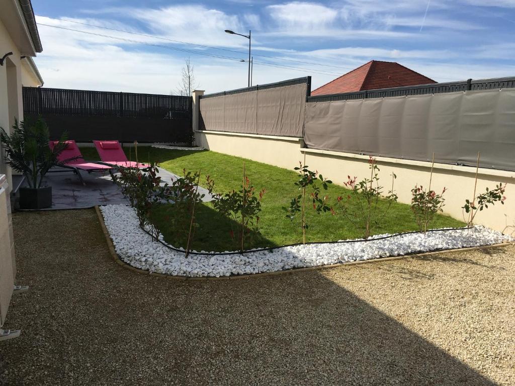 einen Hinterhof mit einem Garten mit Pflanzen darin in der Unterkunft Troyes villa clim 3 ch 6 pers in Saint-André-les-Vergers
