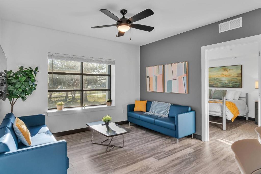 a living room with two blue couches and a ceiling fan at The Well #209 Apartment in Zephyrhills