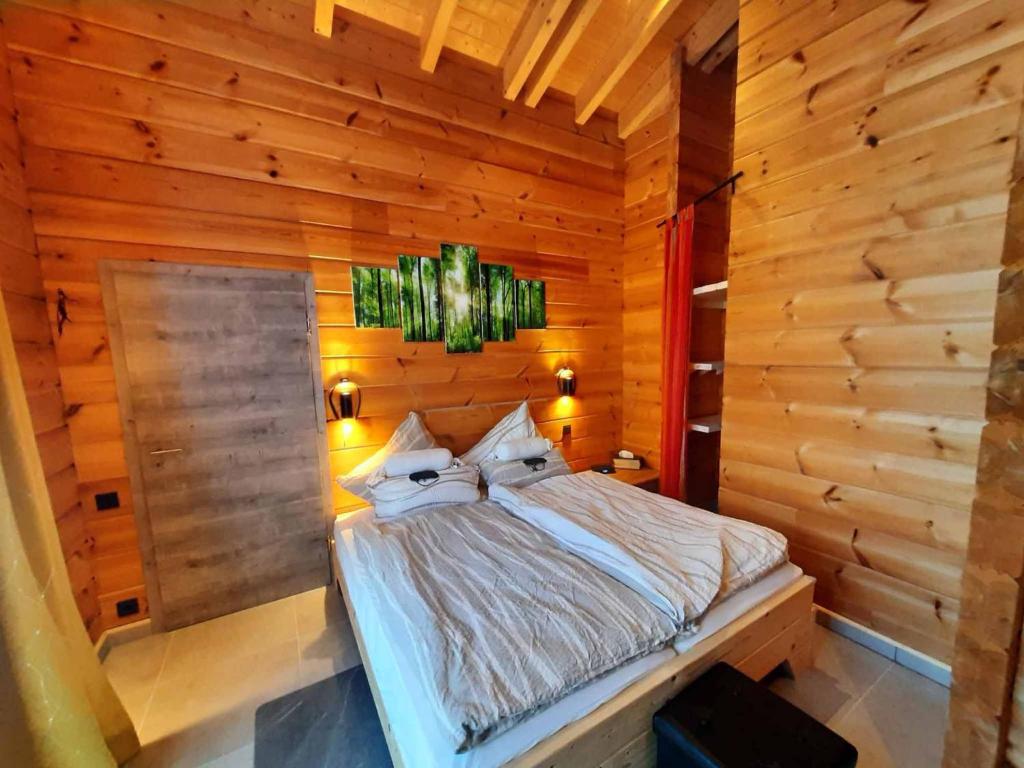 ノイシェーナウにあるBlockhaus am Baumwipfelpfadの木製の壁のベッドルーム1室