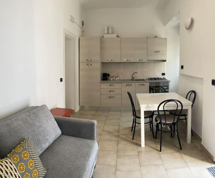 een woonkamer met een bank en een tafel en een keuken bij Ca del Luf in Arlate
