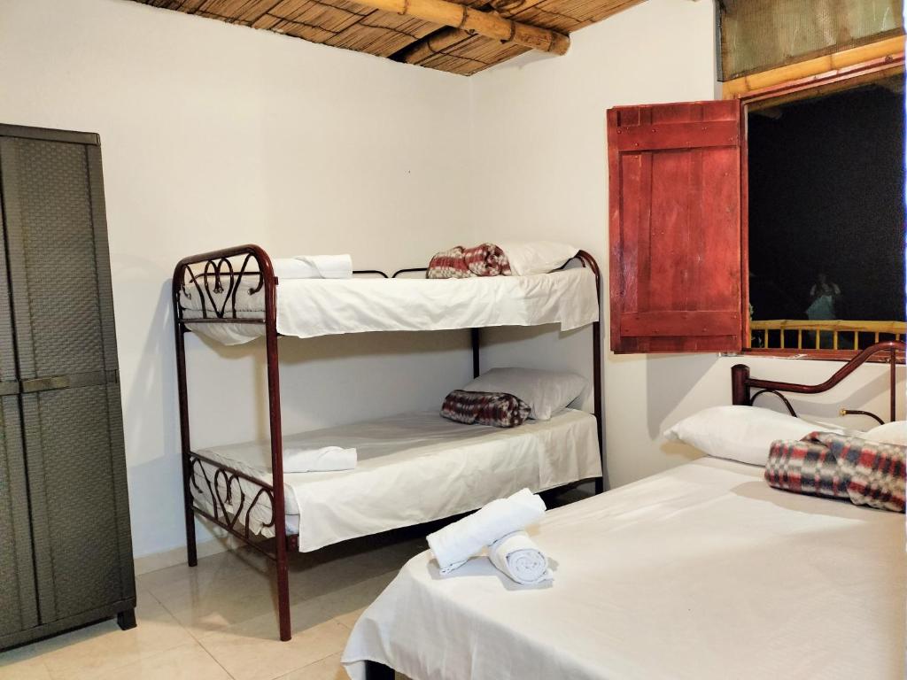 Zimmer mit 3 Etagenbetten und einem Fenster in der Unterkunft CARRIQUI in Calarcá