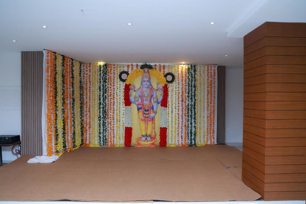 a room with a large painting on the wall at Hotel Mangala Temple View in Guruvāyūr