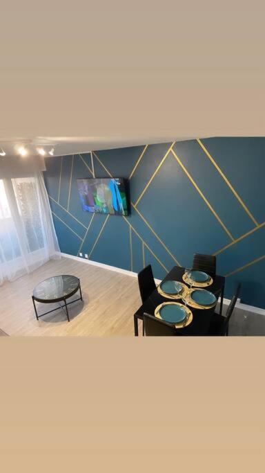 Cette chambre dispose de 3 chaises, d'une table et d'une télévision. dans l'établissement Hibiscus : T2 Melun, à Melun