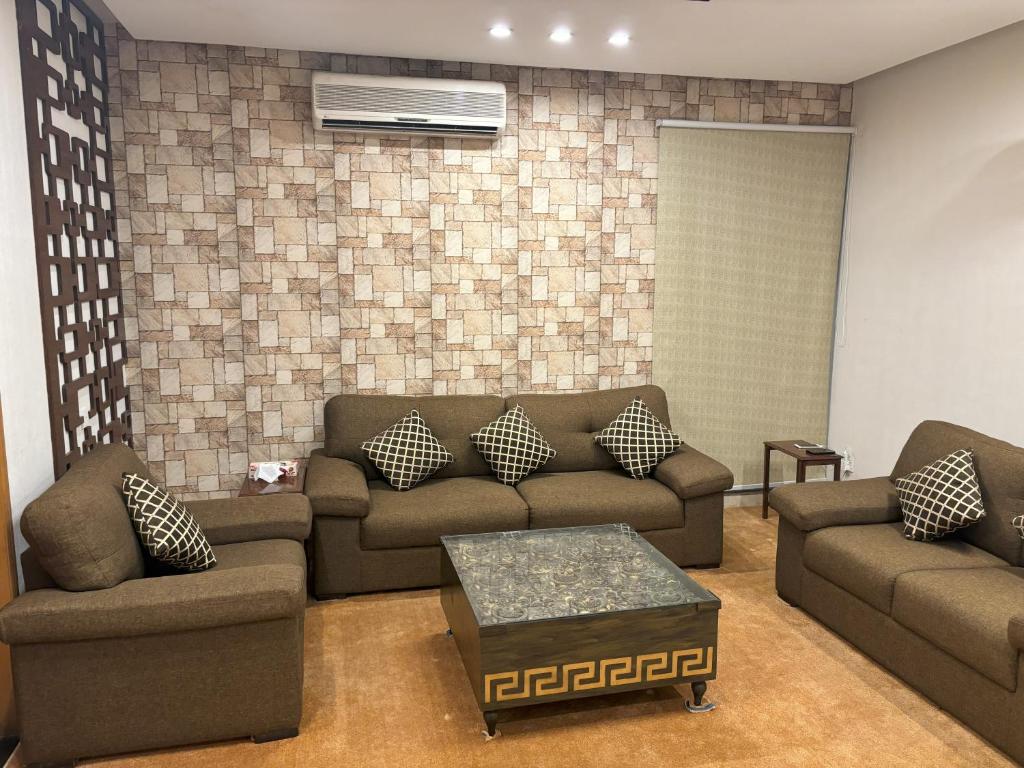 a living room with two couches and a table at 3-Bedrooms Luxury Apartment in Lahore