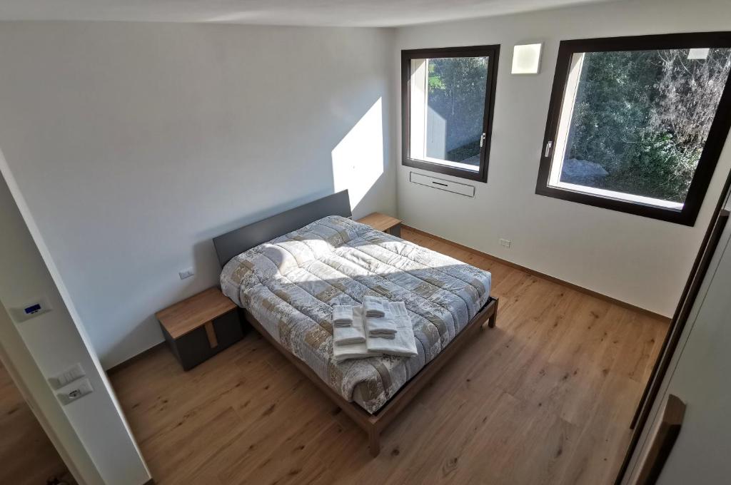 een kleine slaapkamer met een bed en 2 ramen bij Locazione La Scacchiera in Padua