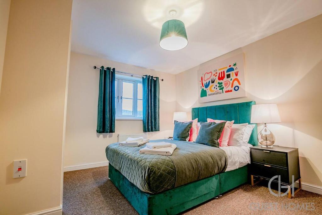 a bedroom with a green bed and a window at Blackthorn in Bury Saint Edmunds