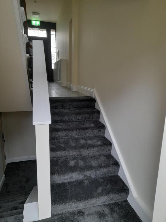 a staircase in a building with a white stair case at Kirkcudbright Holiday Apartments - Apartment A in Kirkcudbright