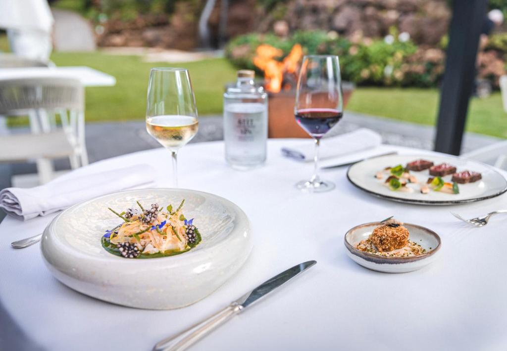 a table with plates of food and glasses of wine at 6717 Nature Hôtel &amp; Spa Le Clos des Délices in Ottrott
