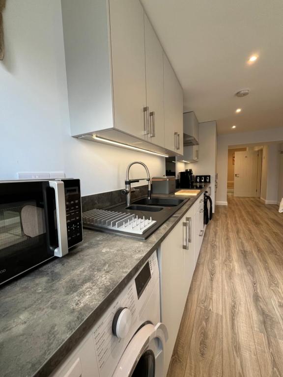 a kitchen with a sink and a microwave at Mary McGill’s in Ballycastle