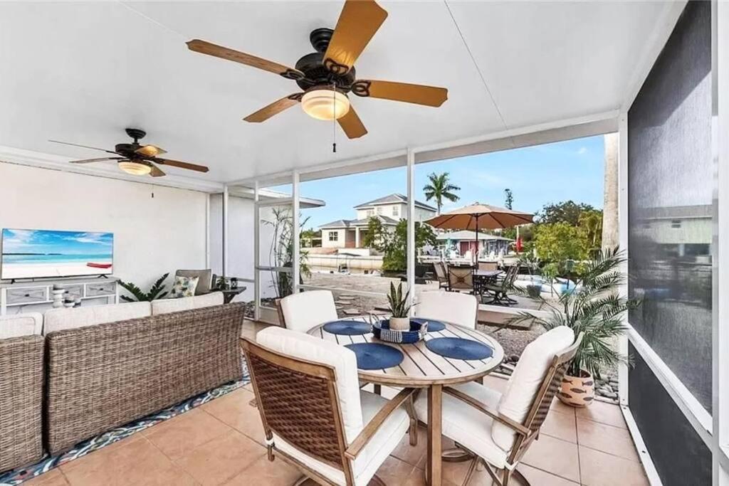 a dining room with a ceiling fan and a table and chairs at Boaters Bayshore Bungalow II in Naples