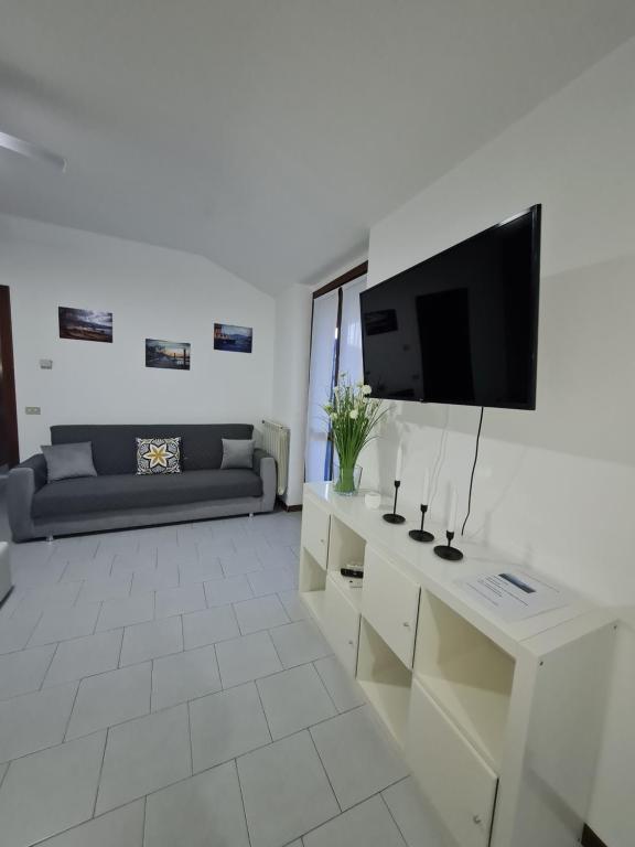 uma sala de estar com uma televisão e um sofá em Casa Amelia lago Maggiore em Maccagno Inferiore