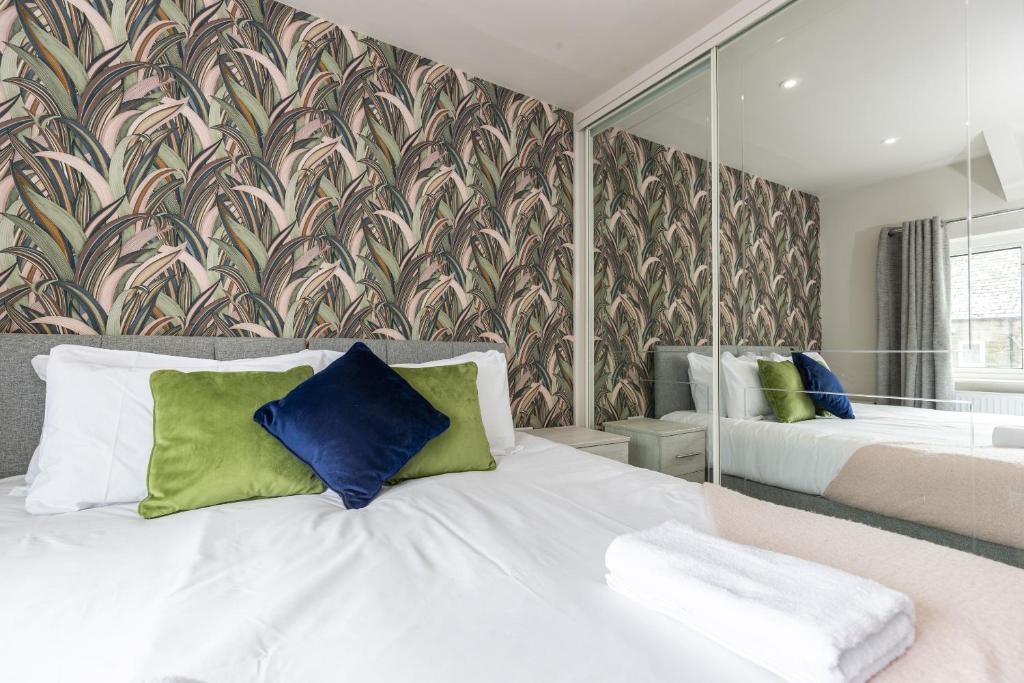 1 dormitorio con cama blanca y espejo grande en H C Property - Doublegait en Barnard Castle