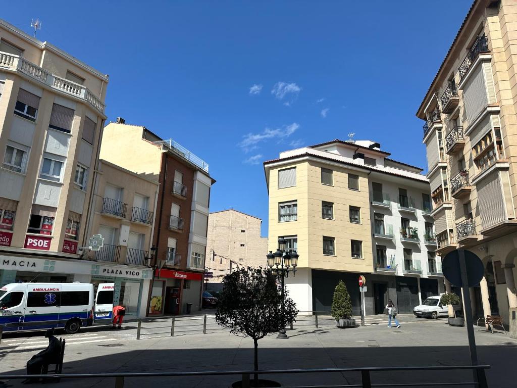 a city street with buildings and a bus at Pensión Arnedo in Arnedo