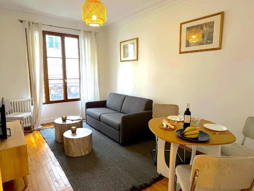 un salon avec un canapé et une table dans l'établissement L' Appartement Richard-Lenoir, à Paris
