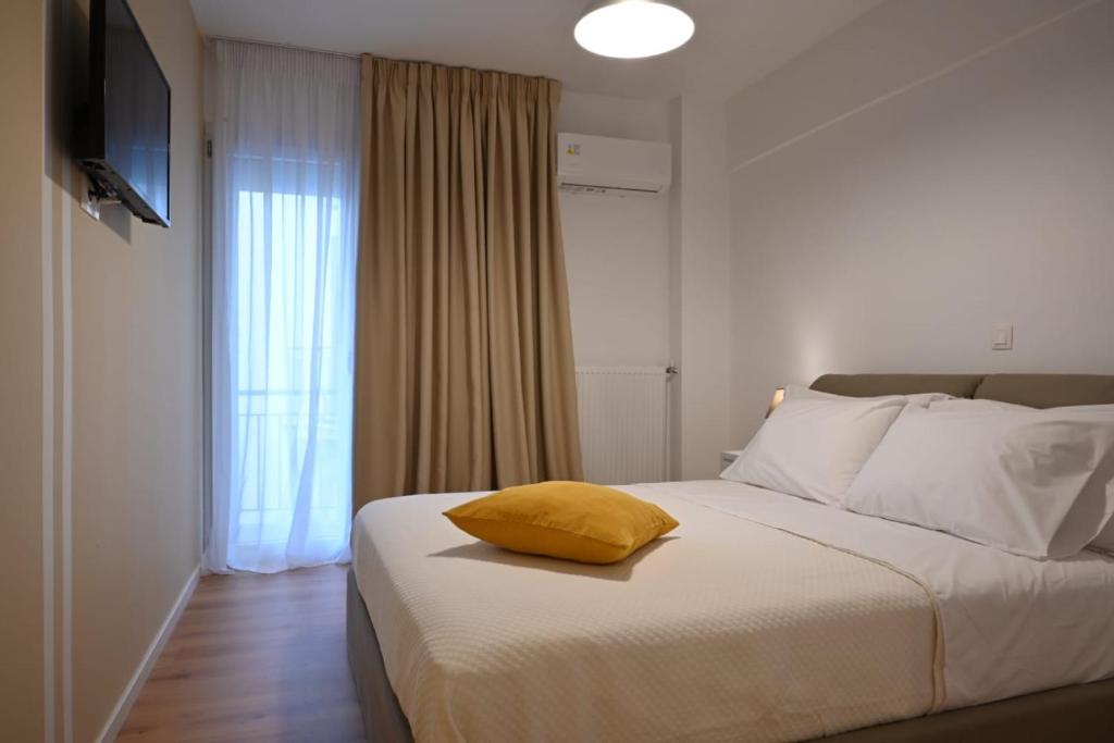 Dormitorio con cama con almohada amarilla en Modern Two Bedroom Apartment At Koukaki, en Atenas