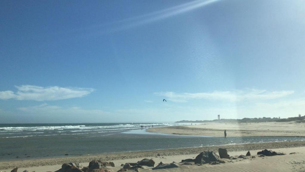 una persona está volando una cometa en la playa en Guest Suite 2 at Rustic Dune, en Jeffreys Bay
