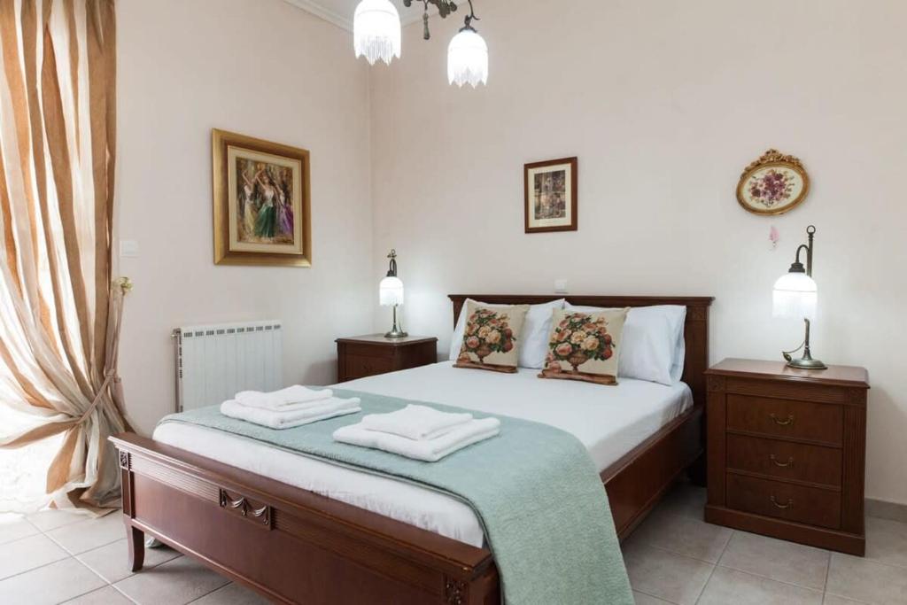 ein Schlafzimmer mit einem Bett mit zwei Nachttischen und zwei Lampen in der Unterkunft Deluxe 2 Bedroom apt in Petroupoli in Athen