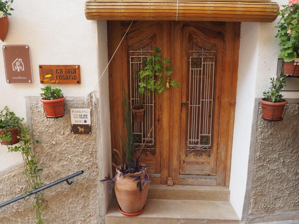 a front door of a house with potted plants at Ca iaia Rosario - Casa rural con catas premiadas, obrador y senderismo in Cuatretondeta