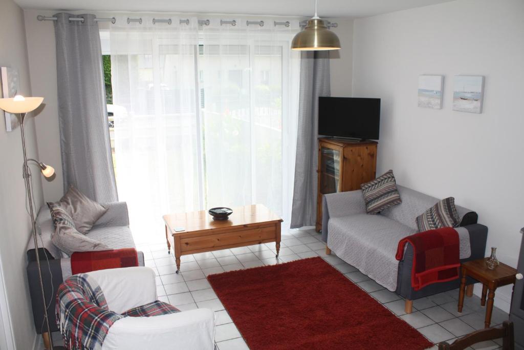 un salon avec un canapé et une table dans l'établissement La Marée, à Portbail