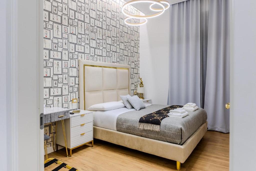1 dormitorio con cama, escritorio y lámpara de araña en Maison 31 -Luxury Apartments, en Santa Marinella
